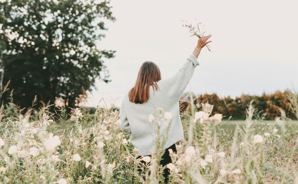 花を掲げて歩く女性の後ろ姿