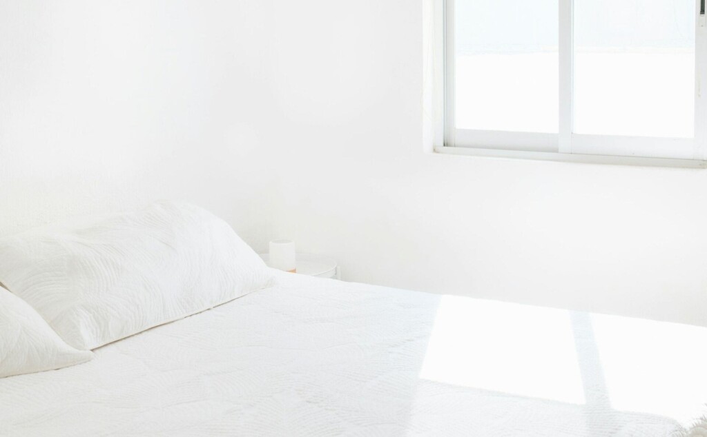窓から光が差し込んでいるベッド