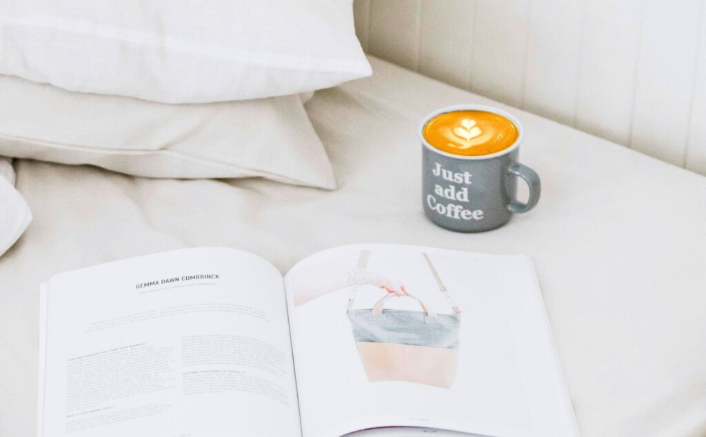 ベッドの上に置いてあるマグカップと雑誌