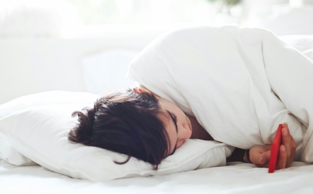 ベッドの中でスマホを見ている人